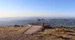 Thumbnail about People standing on a circular viewpoint platform overlooking mountains