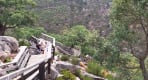 Thumbnail about Visitors climbing wooden stairs along the Paiva Walkways surrounded by forest and rocky landscape.