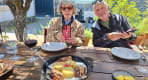 Thumbnail about Quinta do Seixo lunch with guests seated around round table, wine glasses, plates, warm lighting, and restaurant interior