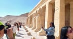 Thumbnail about Tourists taking photos along the stone pillared balcony of Hatshepsut Temple in Luxor 