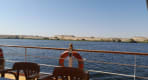Thumbnail about Boat cruising the Nile beside golden desert hills