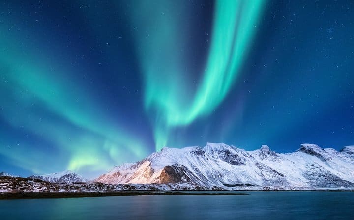 Northern Lights over a snow-covered mountain in Iceland