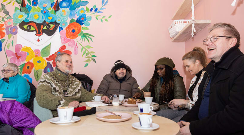 Travellers sitting at a round table enjoying coffee together