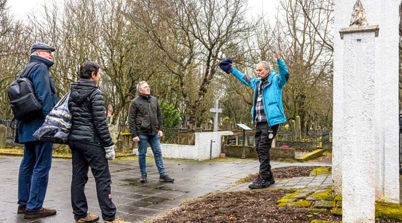 A Guide from Your Friend in Reykjavik telling a story to guests while visiting the oldest Graveyard in Iceland