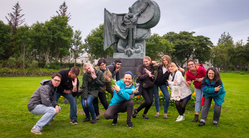 A fun group posing in front of a statue in the park