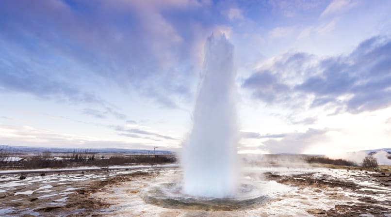 Strokkur winter with blue sky sunrise