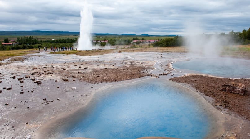 Blue hot spring with Geysir in distance