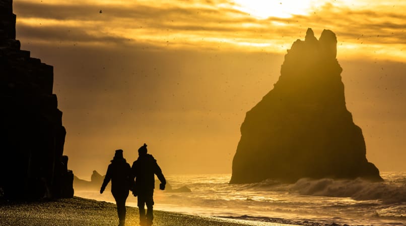 Black Sand Beach with people holding hands and walking