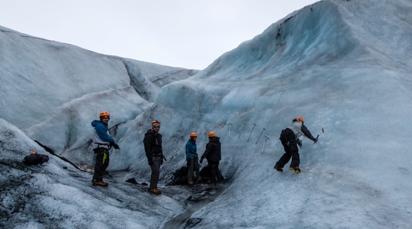 People hiking and climbing on a glacier
