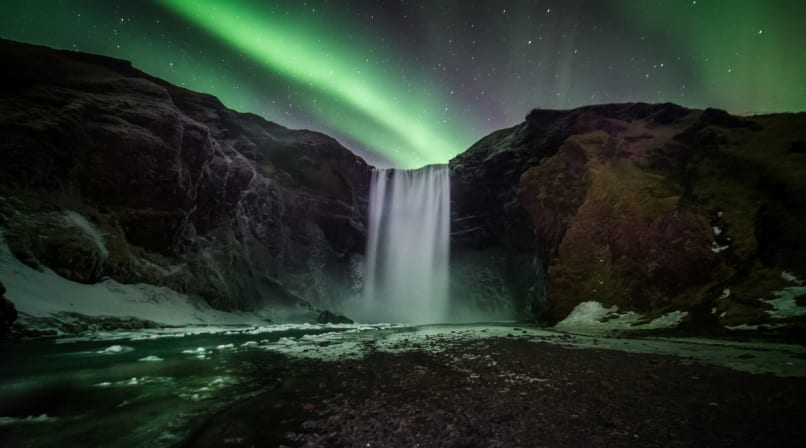 Beautiful northern lights over Skógarfoss waterfall Iceland
