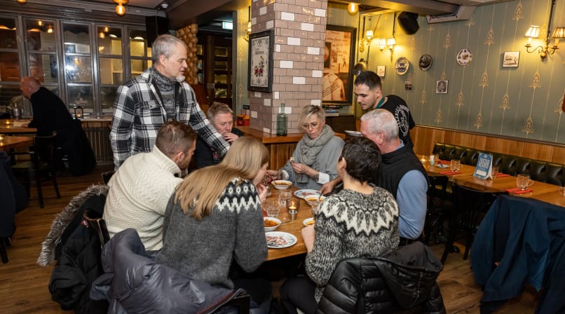 A small group of guests enjoying Icelandic Meat Soup while sitting at a circular table