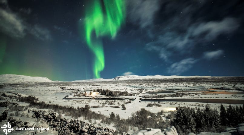 Green Northern lights strip over snowy Thingvellir national park in Iceland