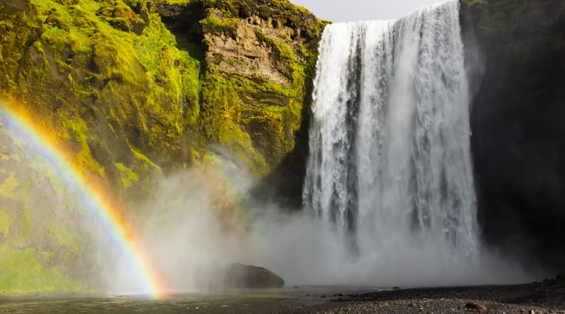 Skógarfoss waterfall decorated with magical rainbow