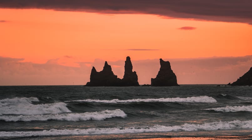 Sunset over petrified trolls called Reynisdrangar