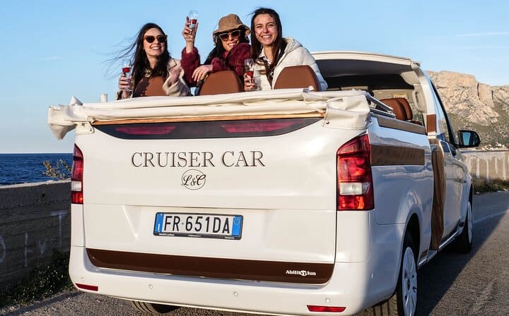 Panoramic view of a tour cruising along the rugged Sicilian coast near Palermo, with tourists admiring the view.