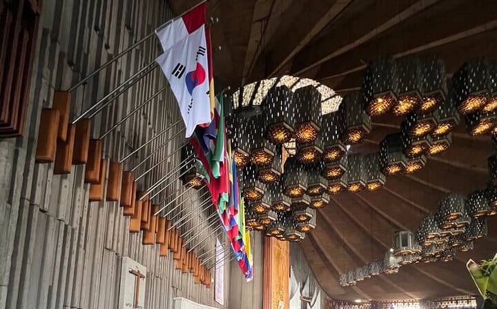 Interior of the Basilica of Guadalupe with its emblematic lamps and flags
