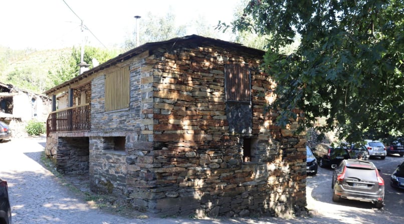 Rustic stone house with wooden balcony in a rural Portuguese village