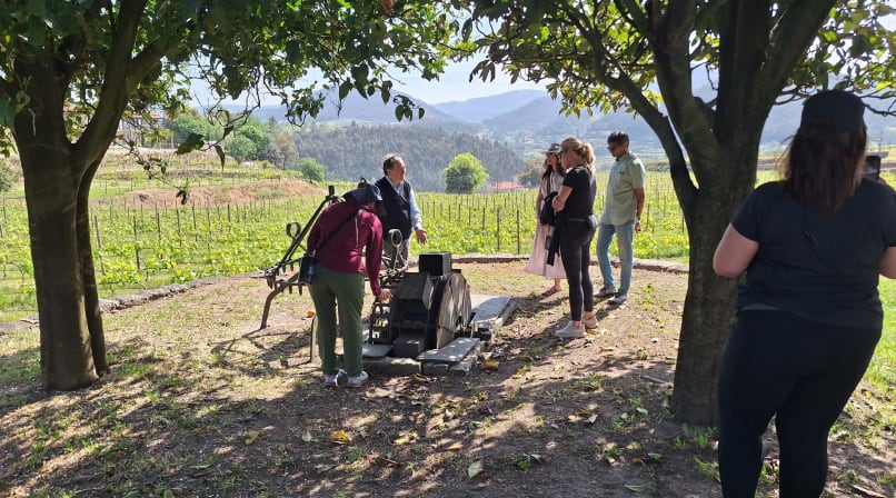 Visitors gathered around traditional wine equipment in a vineyard in Arouca Portugal.