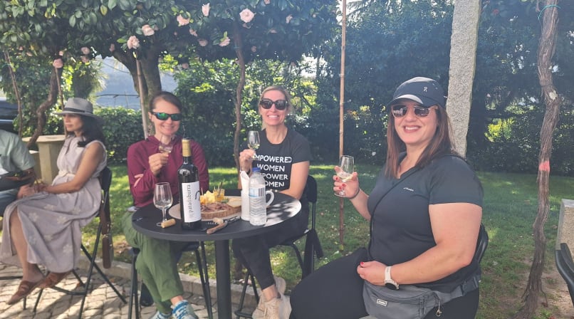 Visitors enjoying wine and local food at an outdoor tasting table in Arouca.