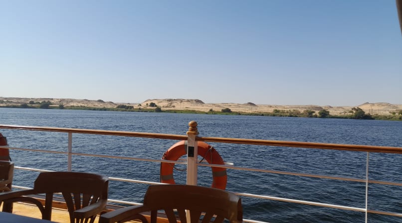 Boat cruising the Nile beside golden desert hills
