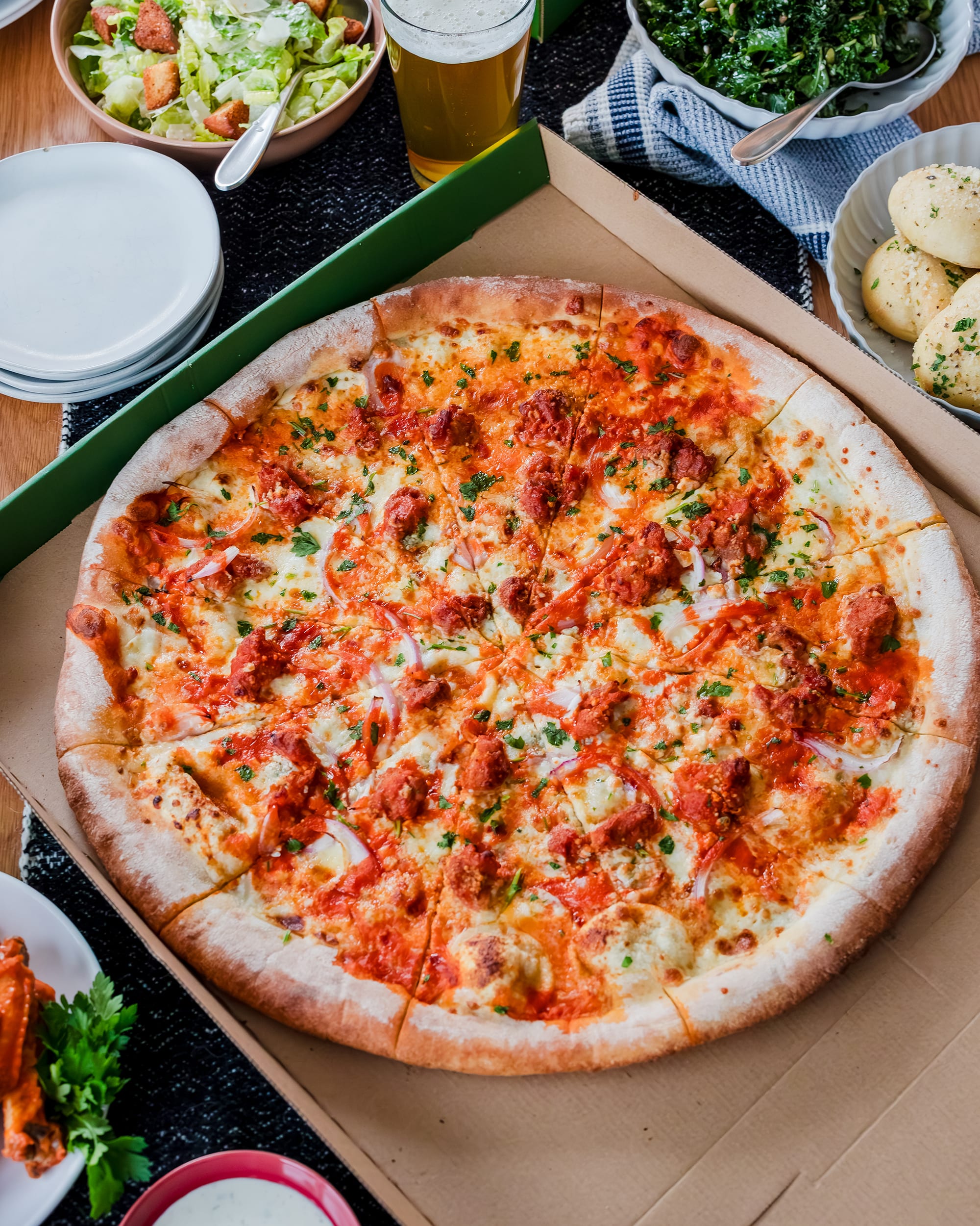 An image of a whole PizzaNW in a cardboard box. 