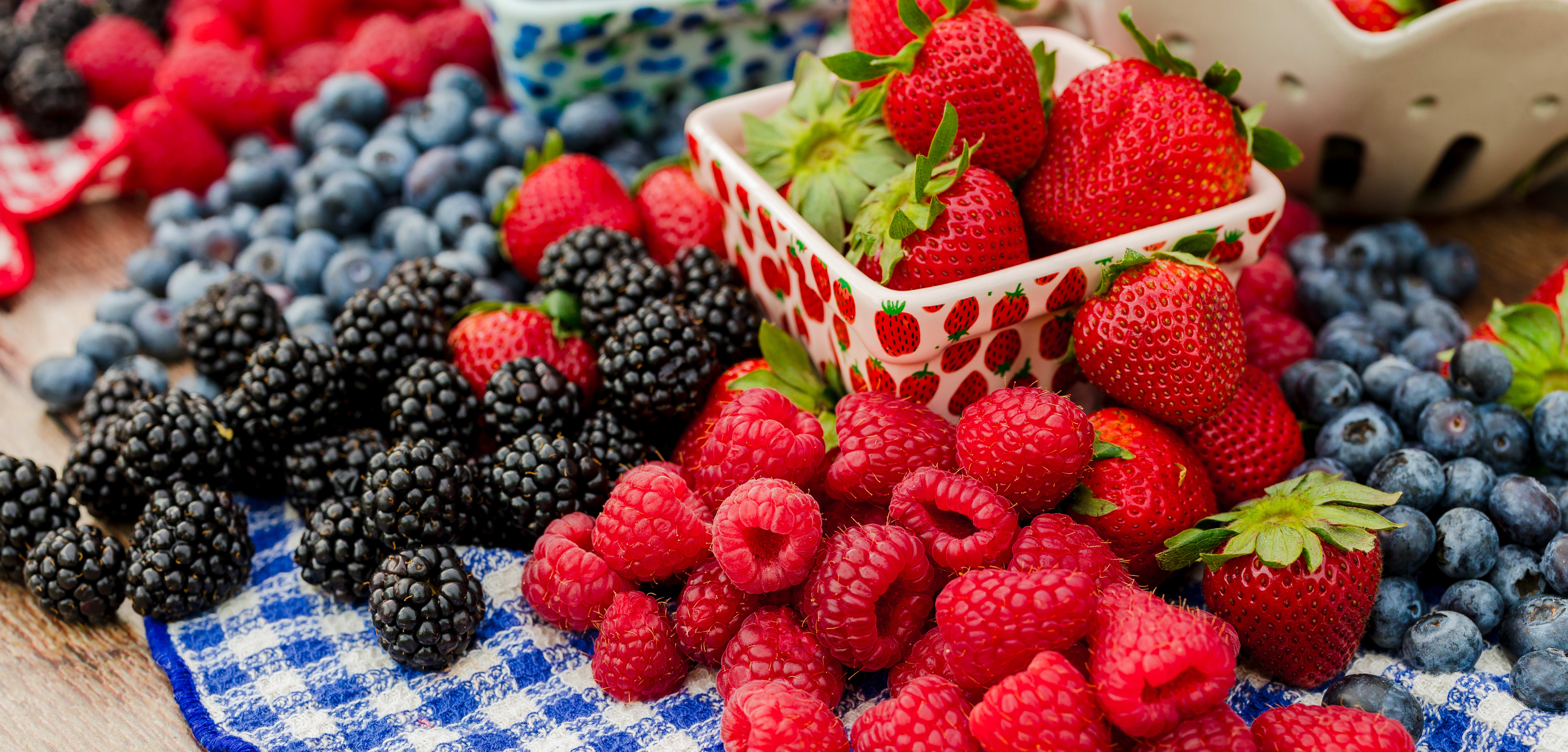 An assortment of local summer berries including raspberries, strawberries, blueberries, and blackberries