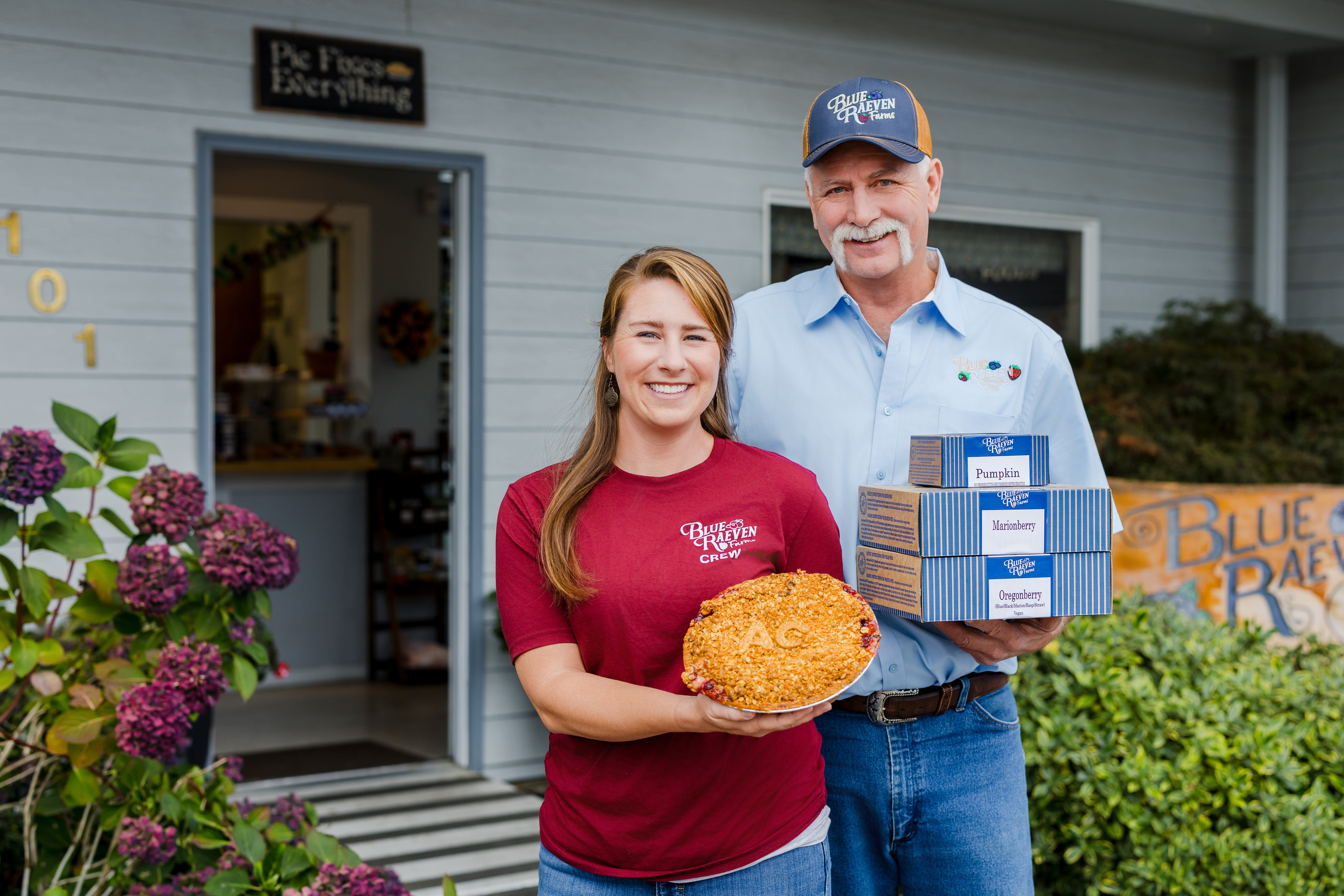 Ron Lewis and Jessica Lewis holding Blue Raeven Pies.