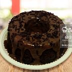 Bolo de chocolate com cobertura e granulados sobre uma mesa