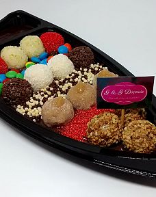 Barco para sushi, porém contendo em seu interior brigadeiros gourmet de vários sabores e confeitos vermelhos, Choco Ball e M&M's.