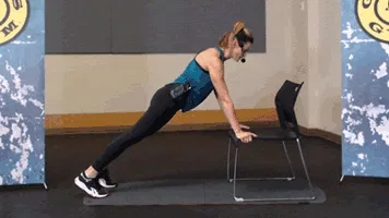 Woman does push-up in gym during chair workout