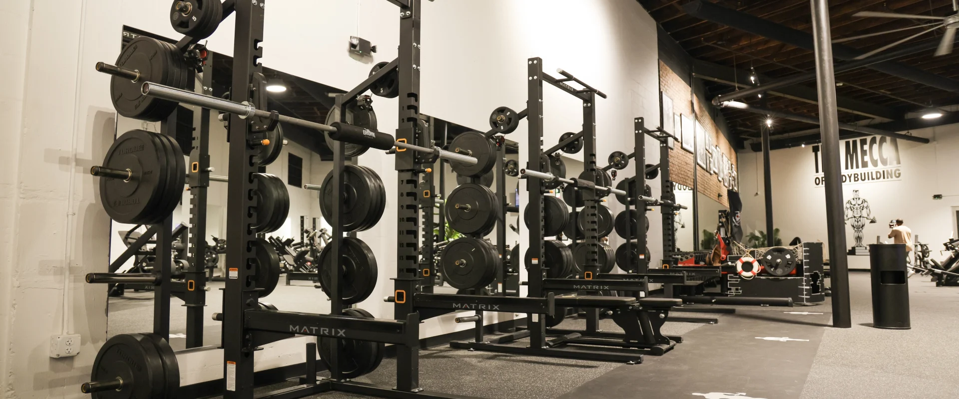 Racks and platforms inside Gold’s Gym (Gas Worx) with loaded barbells and weight stations.