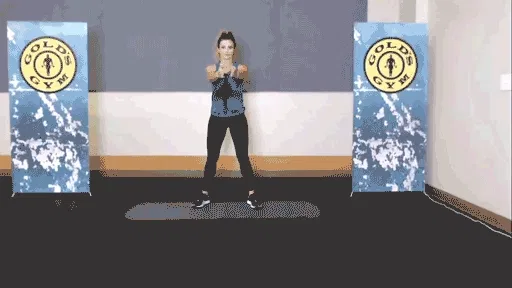 Woman rotating her torso to stretch in the gym.