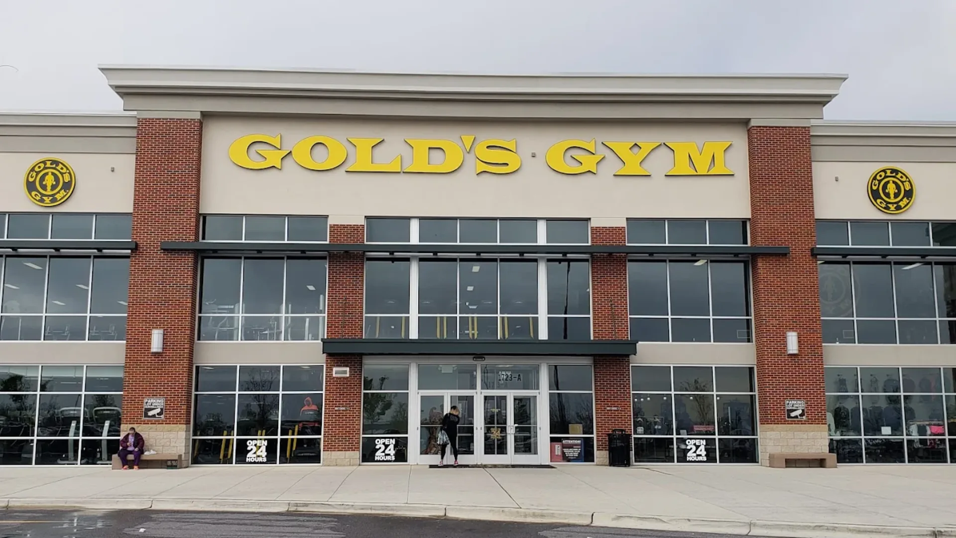 Exterior of Gold’s Gym Capitol Heights with yellow signage, glass windows, and open 24 hours signs at the entrance.