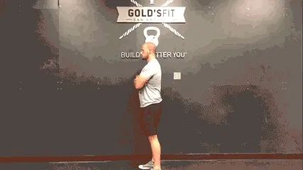 Man doing daily movement routine in the gym with a forward hang exercise