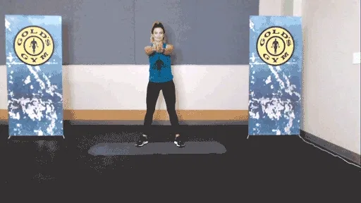 Woman rotating her torso to stretch in the gym.