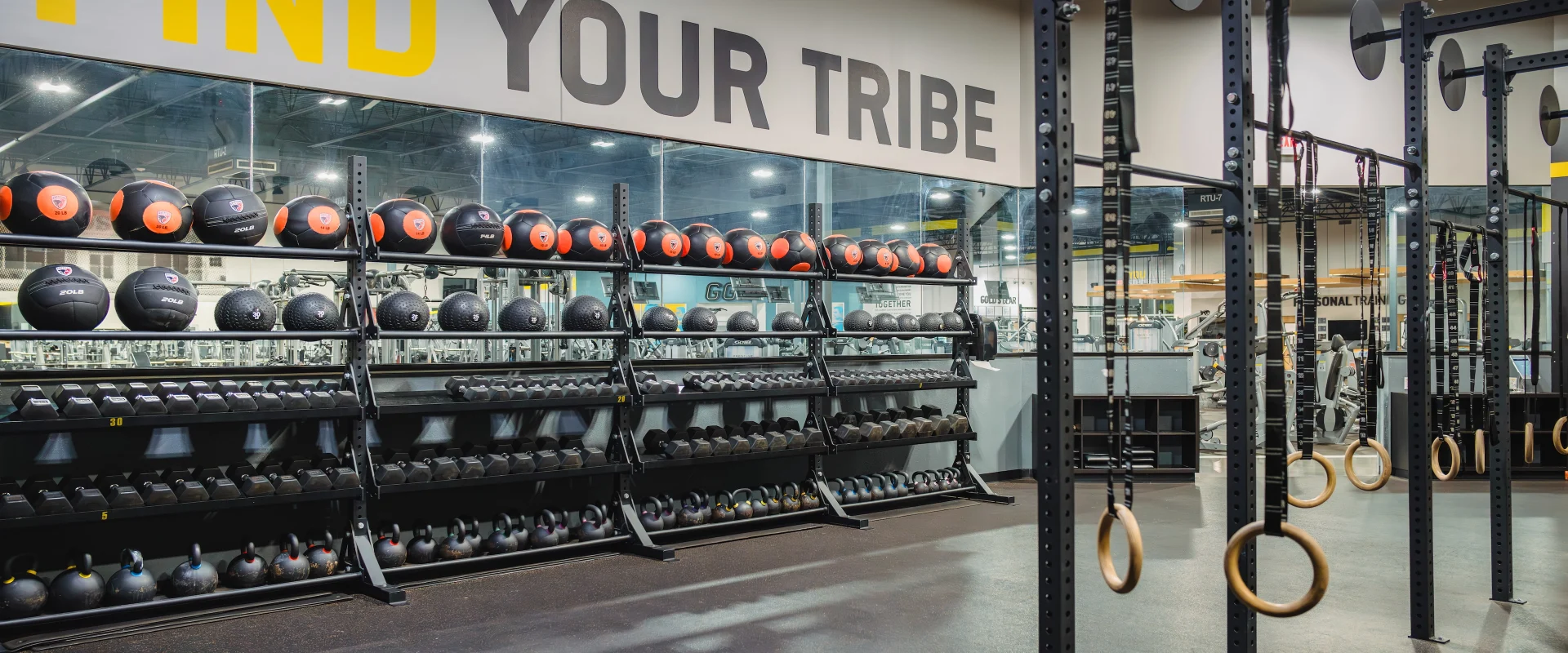 The functional training area at Gold's Gym in Texas (Slaughter & South Congress) includes a rig with pull-up bars, gymnastic rings, and suspension trainers. Nearby, shelves are stocked with kettlebells, medicine balls, and battle ropes, offering versatile options for high-intensity workouts.