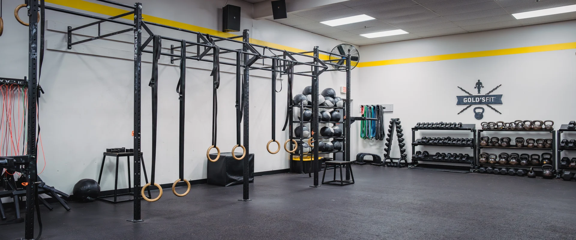 Gold’s Fit studio at Gold’s Gym in Austin (South Central), featuring functional training equipment including gymnastic rings, medicine balls, kettlebells, and resistance bands. The space has a large rig for pull-ups and suspension exercises, along with plyometric boxes and free weights. Rubber flooring and bright overhead lighting create an open, versatile environment for high-intensity workouts.