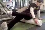 The image shows a person lying on a couch or similar surface, with another person assisting or interacting with them in what appears to be a residential or indoor setting.