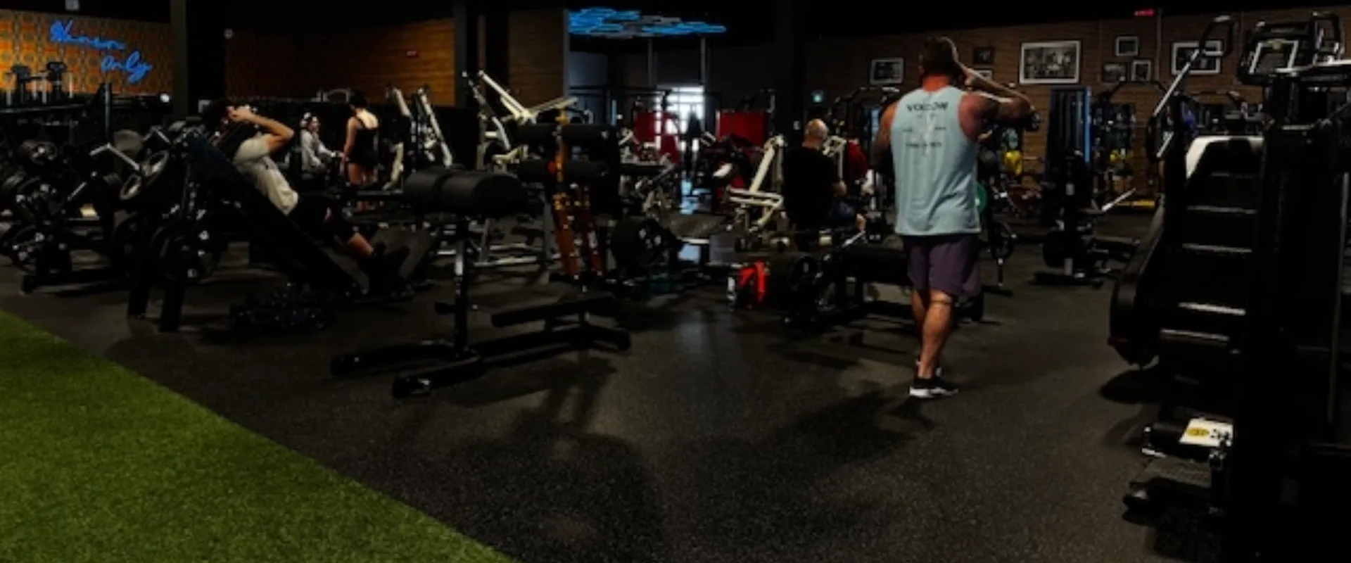 Spacious weight room with turf, machines, plate-loaded machines.
