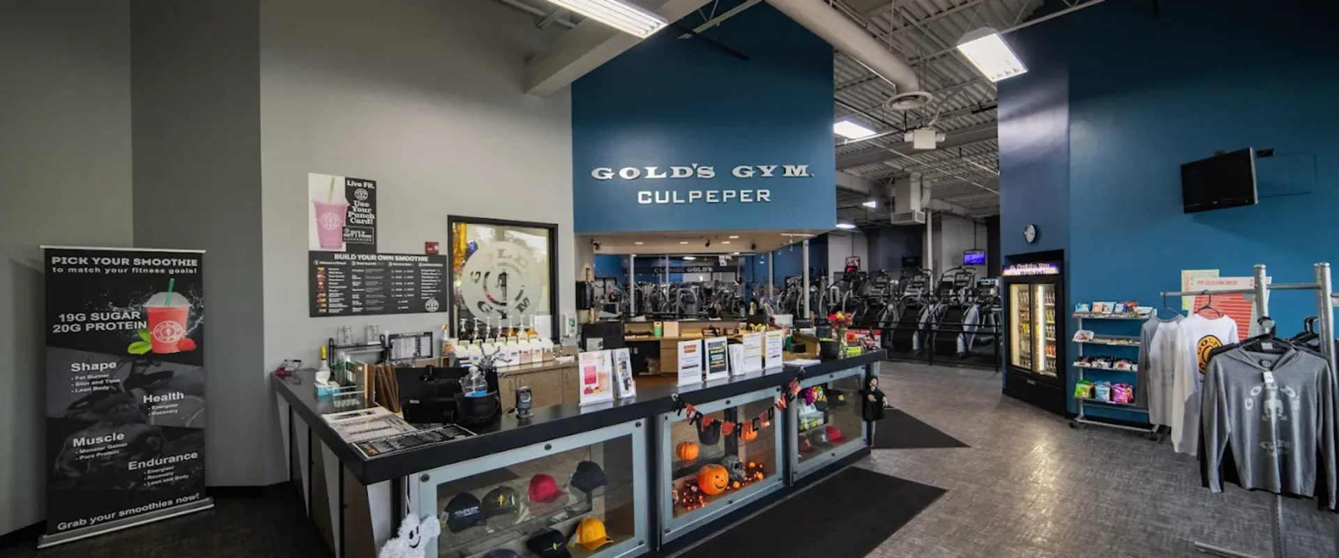 Interior of Gold’s Gym Culpeper with front desk, smoothie bar, and gym equipment in the background.