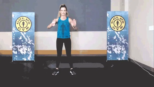 Woman rolling her wrists to stretch her hands in the gym.