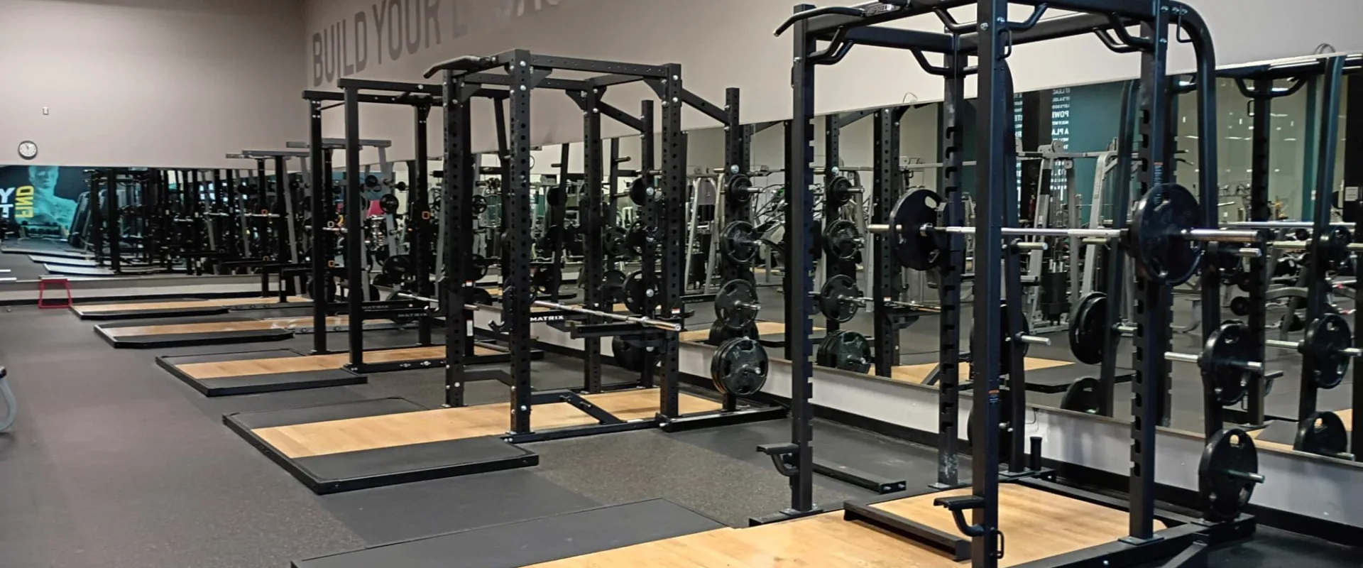 Multiple squat racks and Olympic lifting platforms inside Gold’s Gym South Texas in Harlingen.
