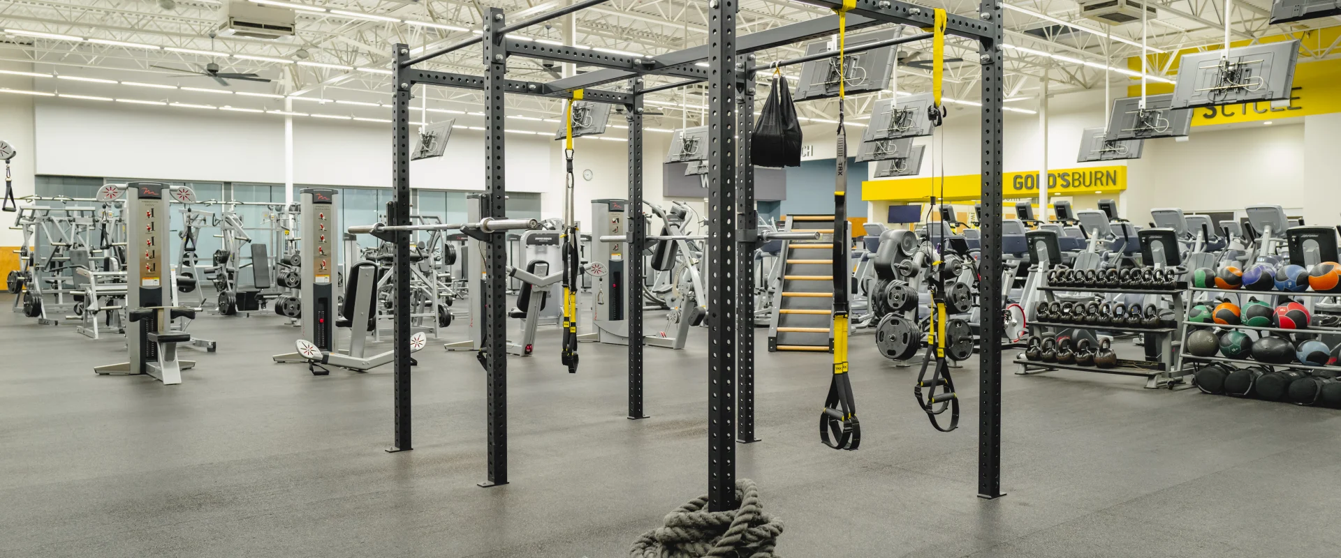 HIIT training area at Gold's Gym featuring a functional training rig with suspension trainers, battle ropes, and a variety of strength equipment. The surrounding area includes kettlebells and medicine balls, providing a versatile space for high-intensity workouts.