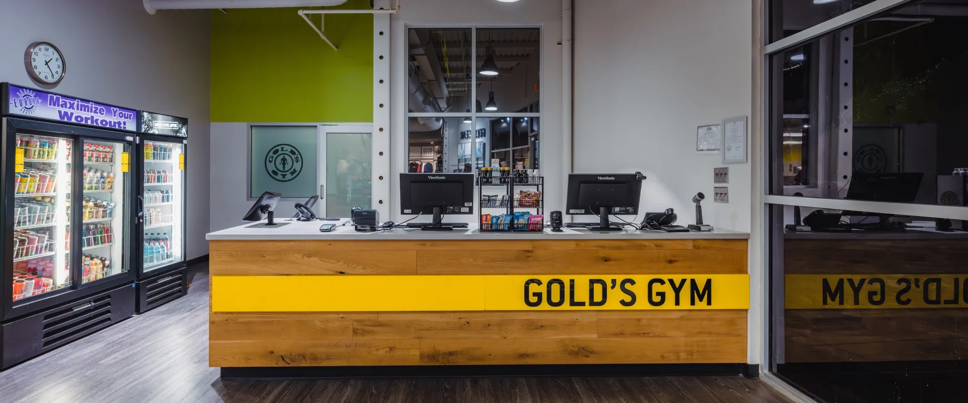 Gold's Gym Live Oak front desk with two computer monitors, snacks and drink vending available to welcome guests when they arrive.