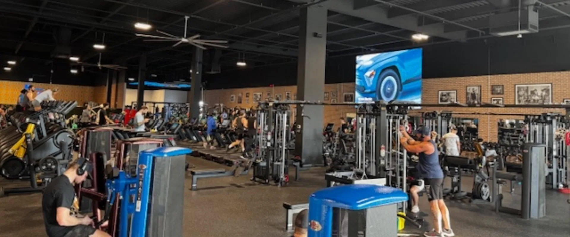 Strength training area with gym80 machines and a TV screen.