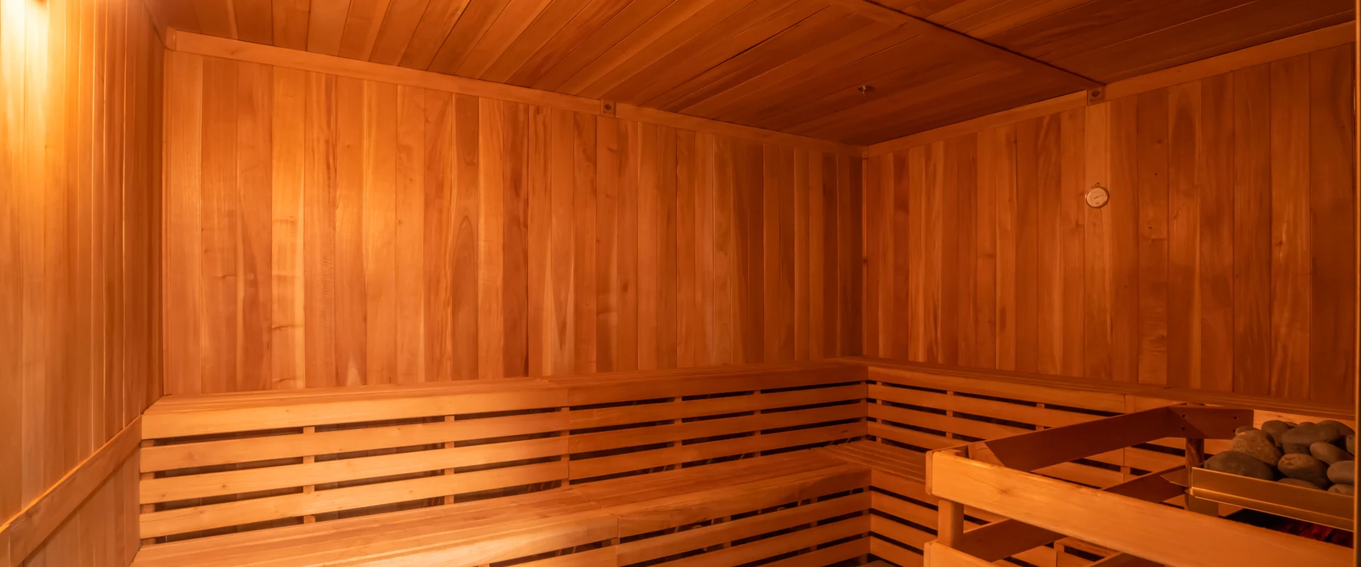 A cozy wooden sauna interior with benches and a warm, inviting atmosphere.