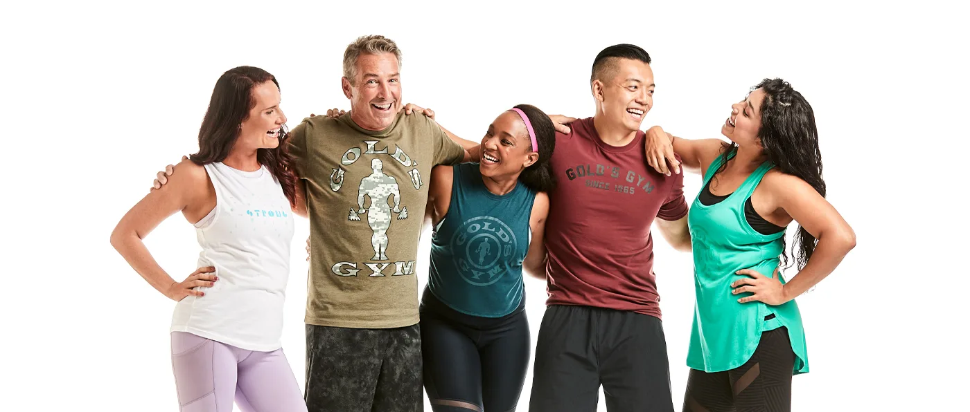 A group of five young adults, three women and two men, are standing together and smiling happily against a plain white background.