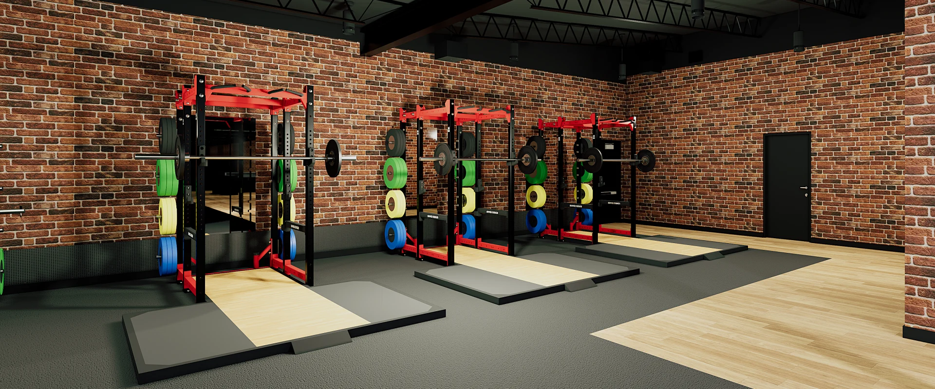 Power rack zone at Gold's Gym Austin (Burnet Rd) with red squat racks, lifting platforms, and bumper plates, lined up along exposed brick walls for Olympic and strength training.