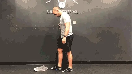 Man doing daily movement routine in the gym with a roll feet exercise