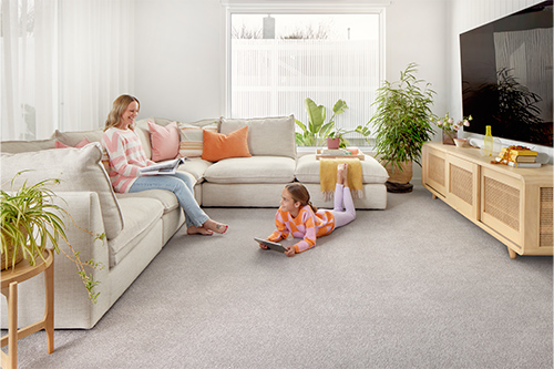 woman and child relax in lounge room with plush carpet